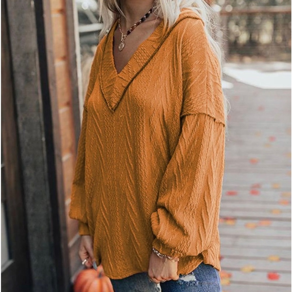 Meritt burnt orange vneck sweater w/exposed black stitching at neck & shoulders